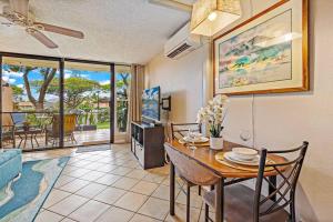 a dining room with a table and chairs and a living room at Maui Condo, 5 minute walk to the beach, 3 Pools, Tennis Courts, BBQs in Kihei