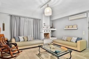 a living room with two couches and a fireplace at Niriides Luxury Apartments in Syvota