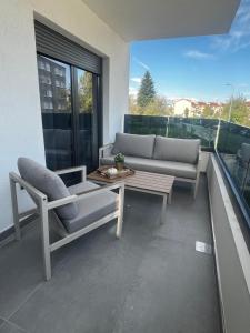 a living room with a couch and a table on a balcony at Apartman Ingrid in Zaprešić +10 photos
