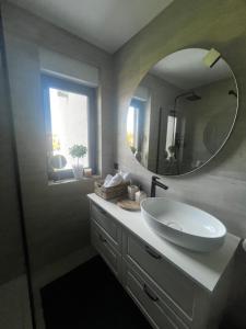 a bathroom with a white sink and a mirror at Apartman Ingrid in Zaprešić