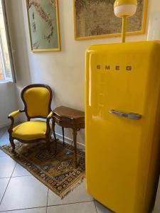 un réfrigérateur jaune à côté d'une chaise et d'une table dans l'établissement Monolocale I Sottomarici nel cuore di Pavia, à Pavia 14 autres photos