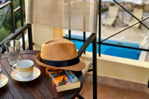 a hat sitting on a table with a cup of coffee at Niriides Luxury Apartments in Syvota