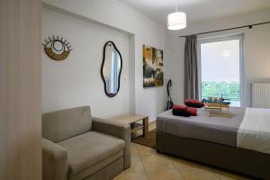 ein Schlafzimmer mit einem Bett und einer Couch und einem Fenster in der Unterkunft Premium Athenian District Urban 1 bedroom flat B in Athen