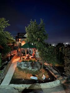 a house with a table and a green umbrella at Villa La Vida in Sarajevo