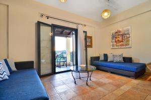 a living room with a couch and a glass table at Niriides Luxury Apartments in Syvota +22 photos