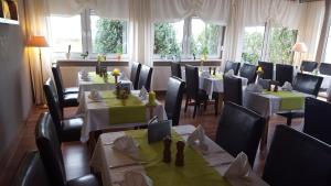 a dining room with tables and chairs in a restaurant at Hotel Zur Fichtenbreite -Garni- in Coswig