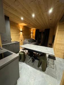 a kitchen with a table in a room with a couch at Appartement familiale Résidence Les Vans Recoin 1650 in Chamrousse