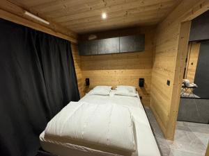 a bedroom with a bed in a wooden room at Appartement familiale Résidence Les Vans Recoin 1650 in Chamrousse