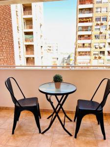 une table et deux chaises avec une plante en pot dans l'établissement Amplio Depto en Pleno Centro!, à Córdoba