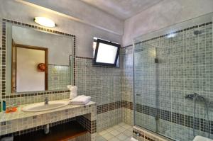 a bathroom with a sink and a glass shower at Niriides Luxury Apartments in Syvota