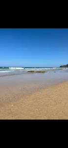 a sandy beach with the ocean in the background at Cousins beach house Three bedroom lodge St Minver in Wadebridge