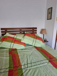 Una cama con un edredón y almohadas de colores en Alelur, en La Paloma