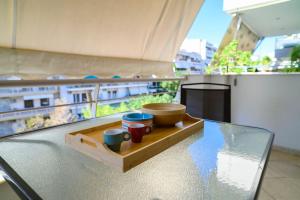 a tray with bowls and cups on a table in a kitchen at Premium Athenian District Urban 1 bedroom flat C in Athens