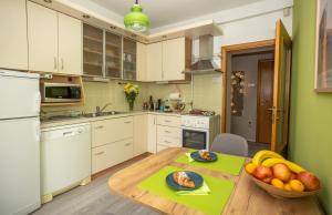 a kitchen with a table with a bowl of fruit on it at Apartman Park in Slavonski Brod