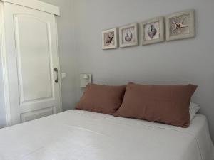 una camera da letto con un letto e due quadri sul muro di Las Américas Islantilla a Islantilla Altre 36 foto