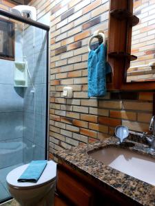 a bathroom with a toilet and a sink and a shower at Pousada Raízes da Guarda in Guarda do Embaú +86 photos