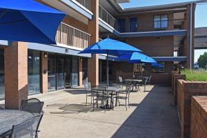 a patio with tables and chairs with blue umbrellas at Days Inn by Wyndham Lebanon in Lebanon