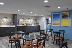 a dining room with tables and chairs and a kitchen at Days Inn by Wyndham Lebanon in Lebanon