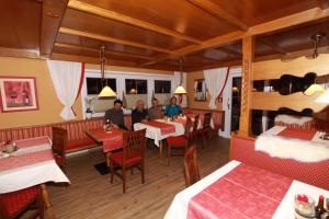 un grupo de personas sentadas en mesas en un restaurante en Pension Edelweiss, en Breitenbach am Inn