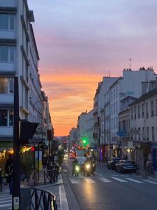 a city street with cars driving down the street at sunset at Lovely Paris appartment in Paris