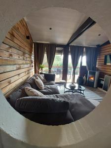 a living room with a large couch in a round room at Chalet tout confort in Virton