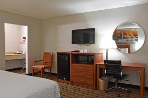 a hotel room with a bed and a desk with a television at Days Inn by Wyndham Lebanon in Lebanon