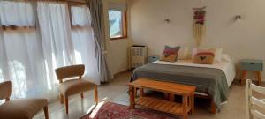 a bedroom with a bed and a table and chairs at Arboleda Monoambiente in El Hoyo