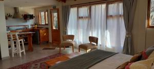 a bedroom with a bed and a desk and a kitchen at Arboleda Monoambiente in El Hoyo +8 photos