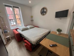 a small room with a bed and a table at Cosy studio au centre d'Obernai in Obernai