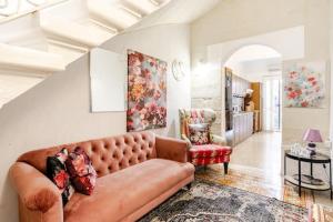 a living room with a couch and a chair at "Spirit of Malta" Historic Maltese Townhouse by the sea in Sliema