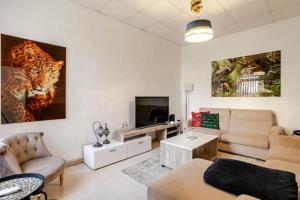 a living room with a couch and a television at "Spirit of Malta" Historic Maltese Townhouse by the sea in Sliema