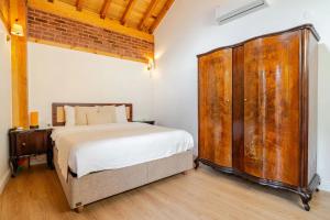 a bedroom with a large bed and a wooden cabinet at Villa Arancia Istanbul - Garden, BBQ, Sauna & Turkish Bath by the Tram in Fatih in Istanbul