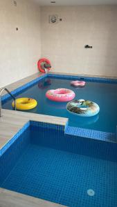 a swimming pool with five colorful inflatable mats in it at calm chalet گالم شالية in Ţaymissah
