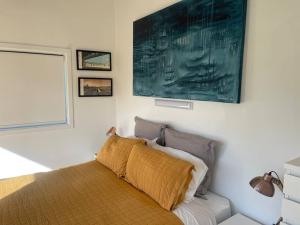 ein Schlafzimmer mit einem Bett und einem großen Gemälde an der Wand in der Unterkunft Marine Bach - Diamond Harbour in Diamond Harbour