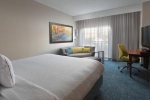 a hotel room with a bed and a chair and a desk at Courtyard by Marriott San Antonio Riverwalk in San Antonio