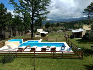 una piscina con un montón de sillas alrededor en Cabañas Agalma, en Villa Yacanto