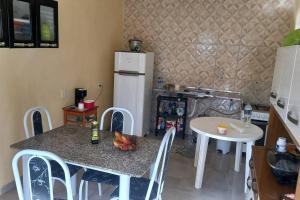a kitchen with a table and a white refrigerator at Recanto de Piranhas de Baixo in Piranhas