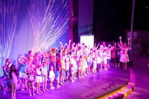 a group of children standing on a stage with their hands in the air at LAUR HOTELS Experience & Elegance in Didim