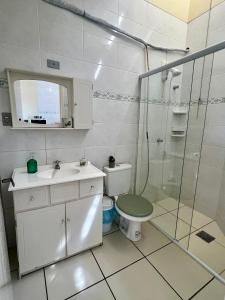 ein Badezimmer mit Dusche, Toilette und Waschbecken in der Unterkunft Lindo Apto Frente Praia 4 Cond Dom Felippe in São Lourenço do Sul