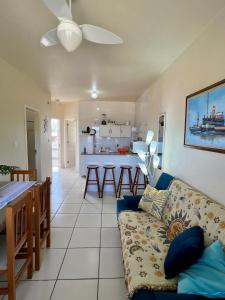 ein Wohnzimmer mit Couch und Küche in der Unterkunft Lindo Apto Frente Praia 4 Cond Dom Felippe in São Lourenço do Sul