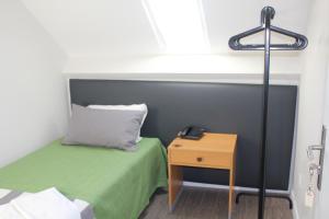a small room with a bed and a night stand at Guest House Porto Clerigus in Porto
