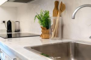 a kitchen counter with a sink and a container with wooden spoons at Martino by PortofinoVip in Portofino +62 photos