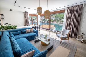 a living room with a blue couch and a large window at Blanche Cliff Apartments in Sveti Stefan