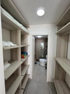 a bathroom with wooden shelves and a toilet at Apartment in Playa Nueva Romana in San Pedro de Macorís