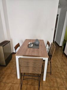 einem Holztisch mit Stühlen und einer Vase darauf in der Unterkunft Centro de Mar del Plata in Mar del Plata + 6 Fotos