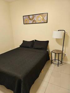 a bedroom with a black bed and a lamp at Heights at Mcoll Luxury Condo #2 in McAllen