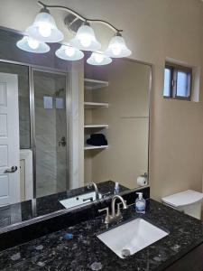 a bathroom with a sink and a large mirror at Heights at Mcoll Luxury Condo #2 in McAllen