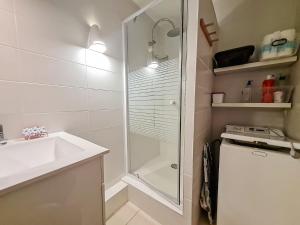 ein weißes Badezimmer mit Dusche und Waschbecken in der Unterkunft Y Hôtes- Ambiance Montagne T2 Station Hirmentaz in Bellevaux + 8 Fotos