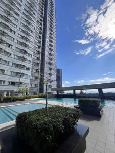 a large apartment building with a swimming pool and a tree at Avida Tower 2 Mountain View Condominium in Davao City +23 photos
