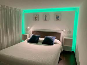 Un dormitorio con una cama con luces verdes. en La Caletta Casa Vacanze, PRIVATE POOL, en Terrasini